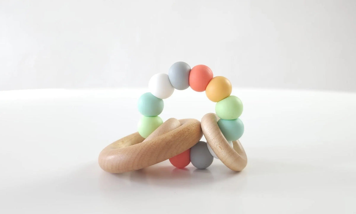 Saturn Ring Teether with muted multicolored silicone beads and wooden rings
