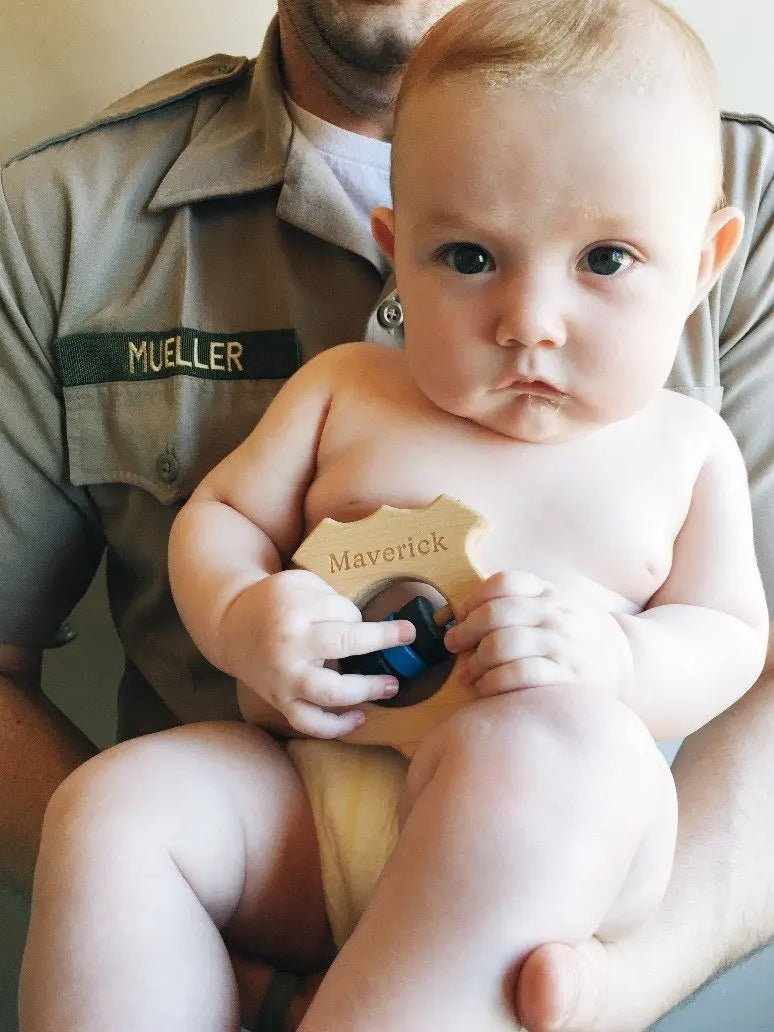 Lifestyle photo showing a wooden baby rattle with a child