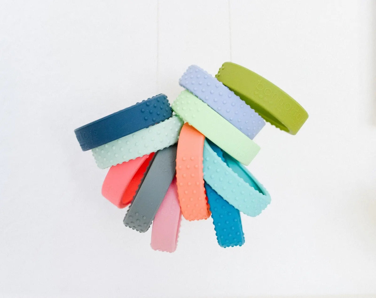 Close-up of textured silicone wraps around wooden teething rings