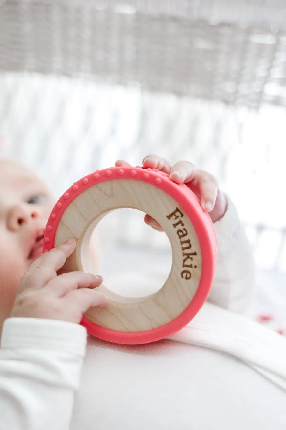 Lifestyle photo showing a wood and silicone teether with a child