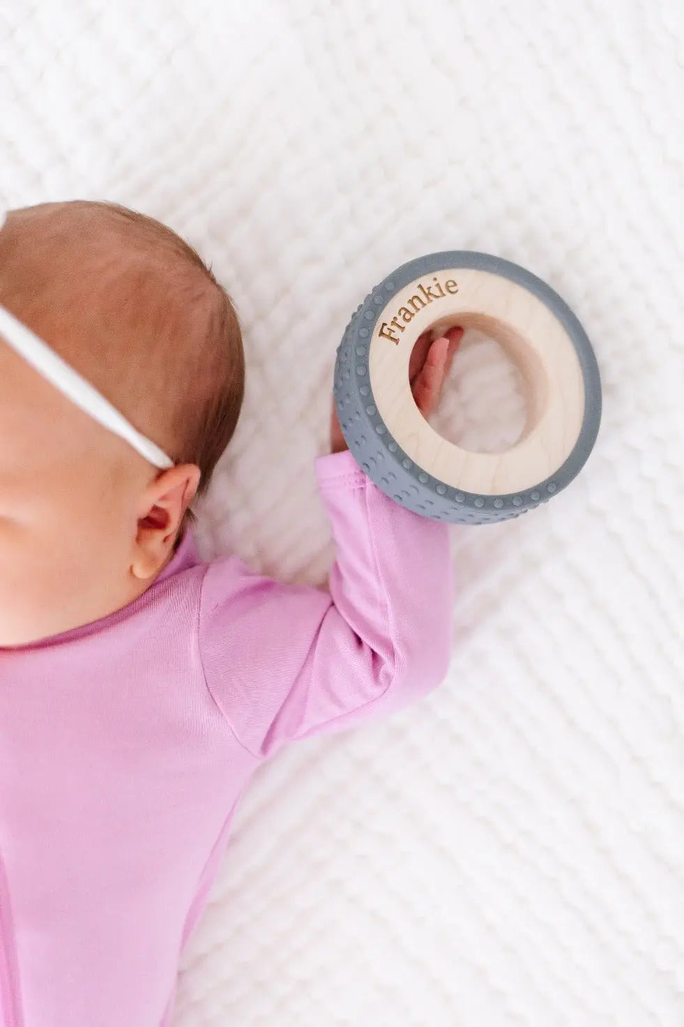 Lifestyle photo showing a wood and silicone teether with a child
