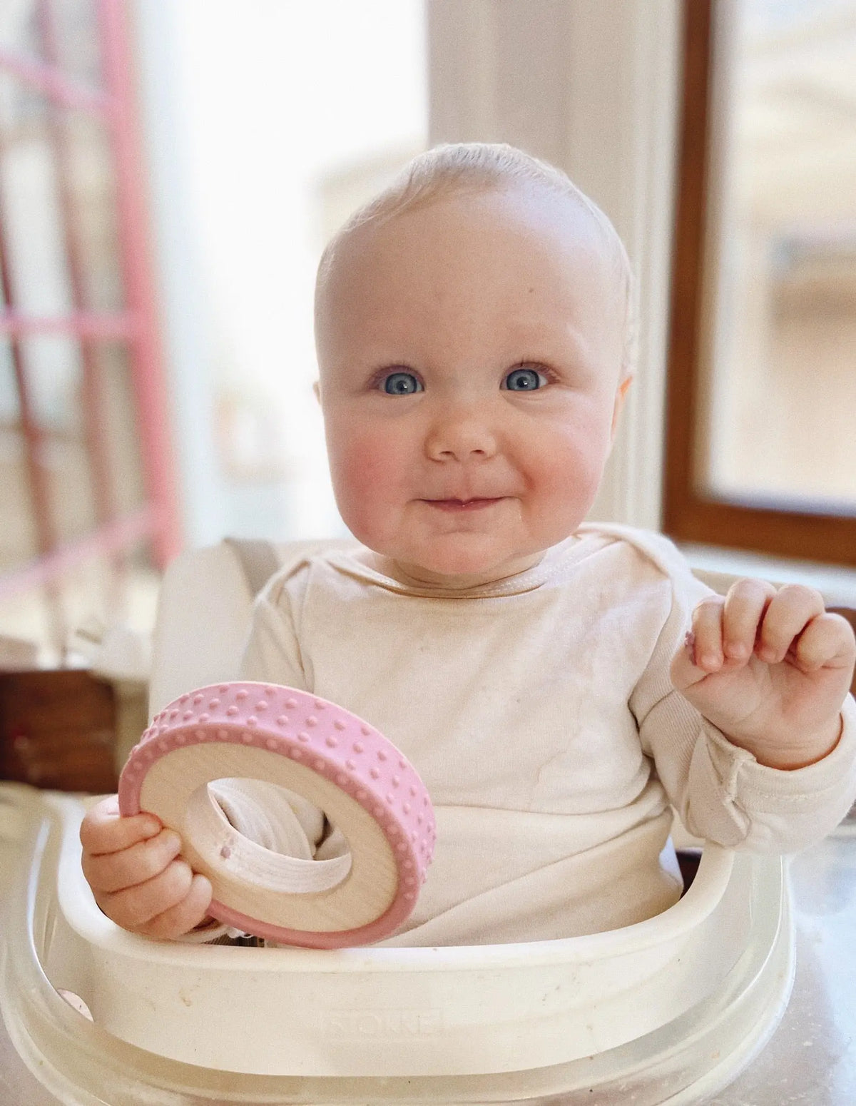 Lifestyle photo showing a wood and silicone teether with a child