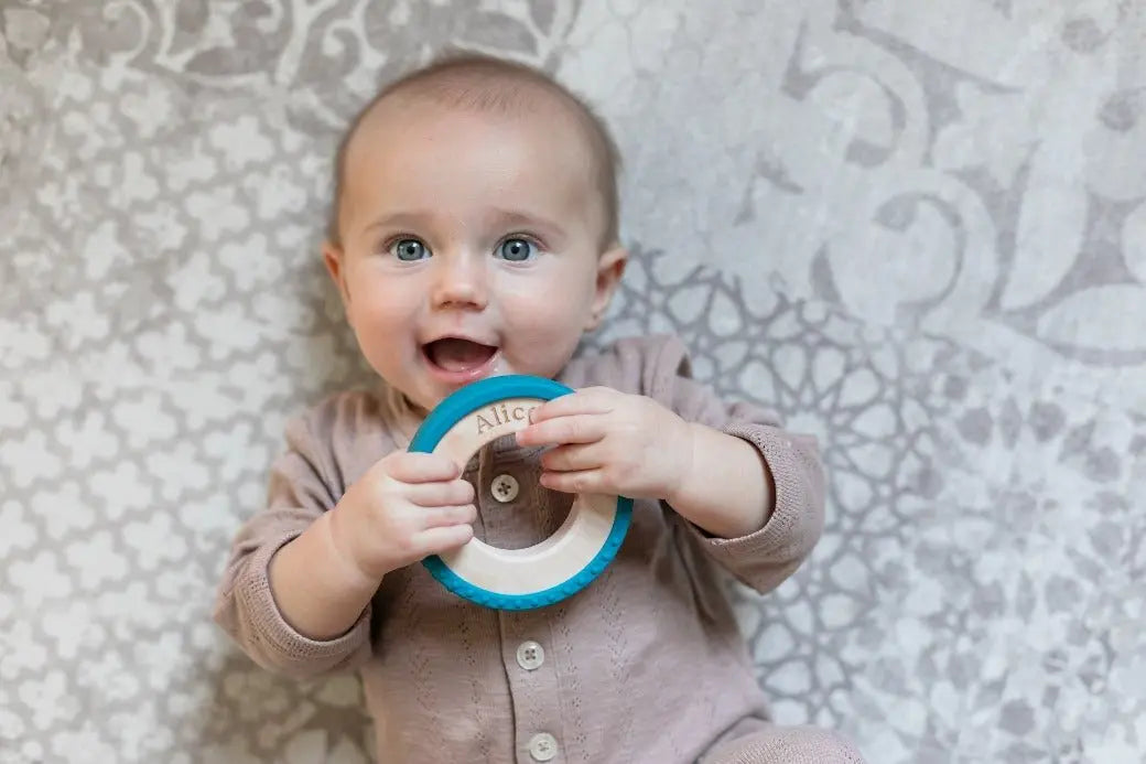 Lifestyle photo showing a wood and silicone teether with a child