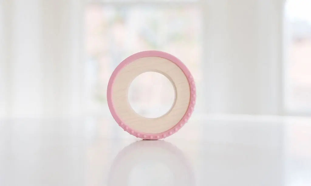 Wooden teething ring with a rose-pink silicone wrap