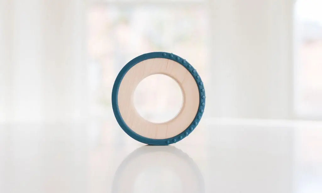 Wooden teething ring with a dark blue silicone wrap