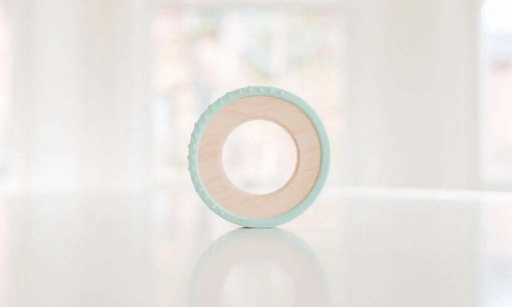 Wooden teething ring with a pale mint silicone wrap