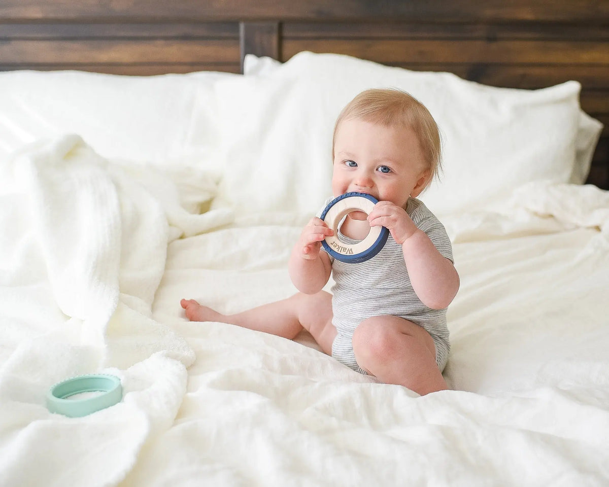Lifestyle photo showing a wood and silicone teether with a child