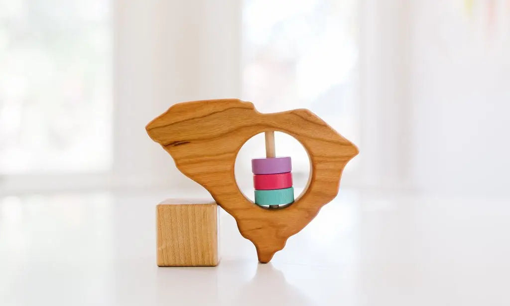 Bannor Toys South Carolina State Wooden Baby Rattle, showing state-shaped cherry-wood body and colored rattle discs