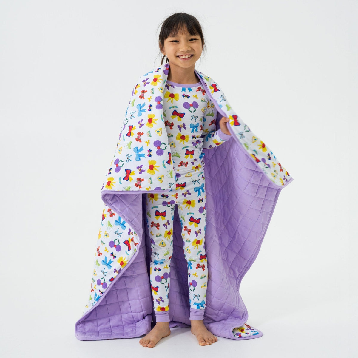 Child holding Bam & Stitch Sparkle & Reign Blanket open at their sides.