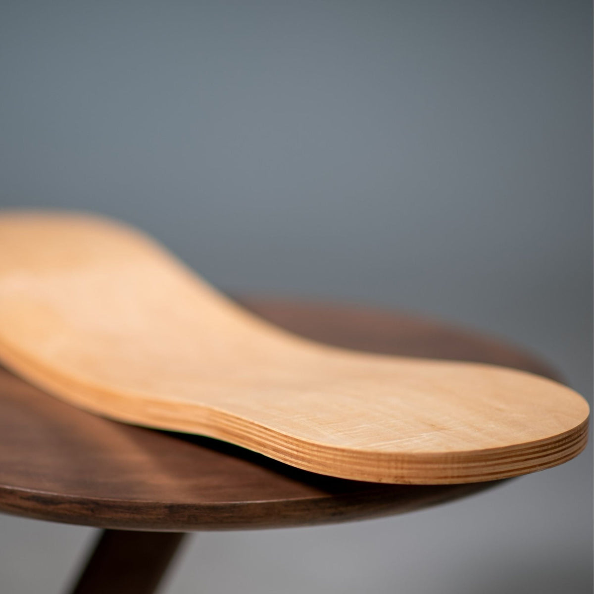 Close-up of a natural-tone Spinzee board showing its curved profile and layered edge.