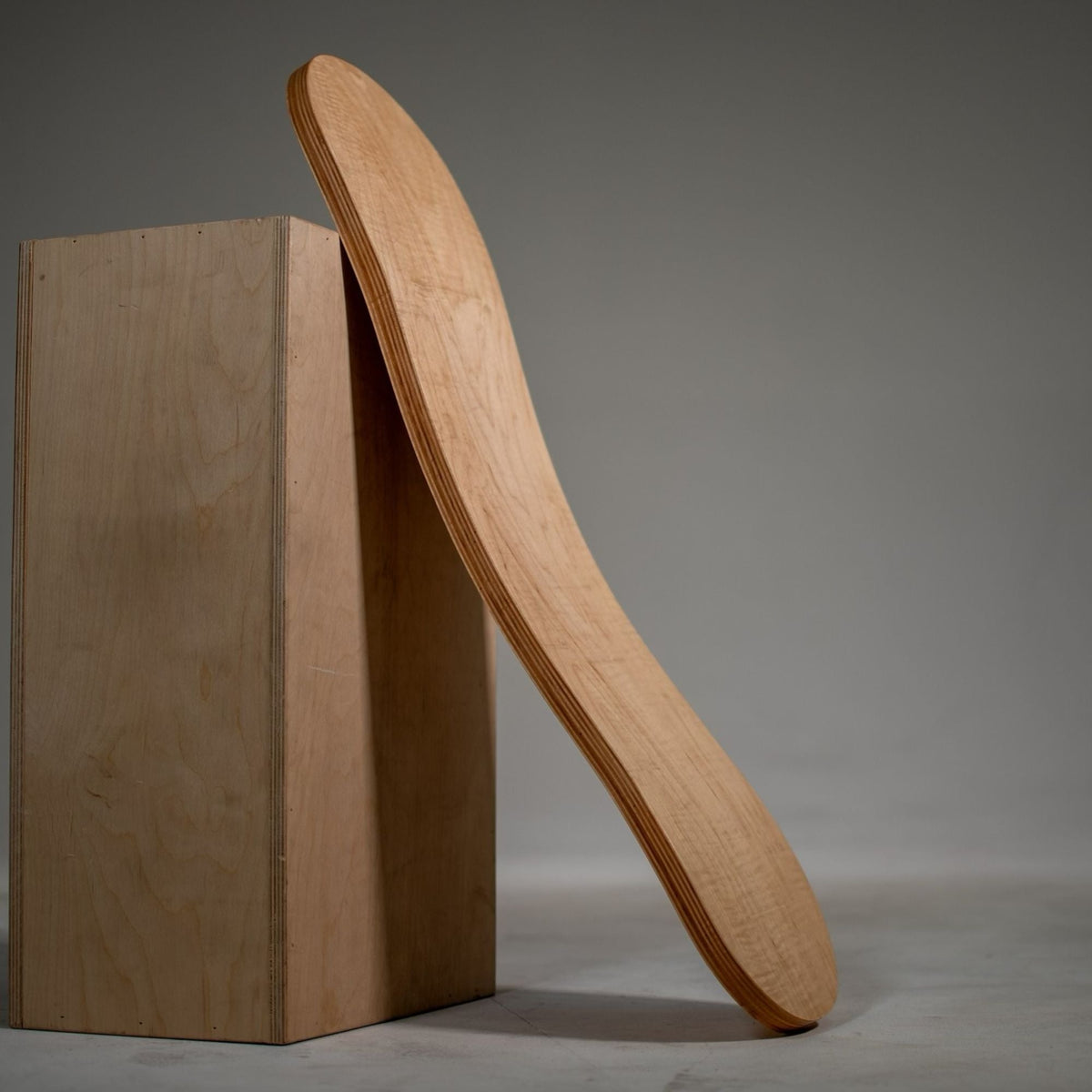 Natural-tone Spinzee board leaning upright against a rectangular display block.