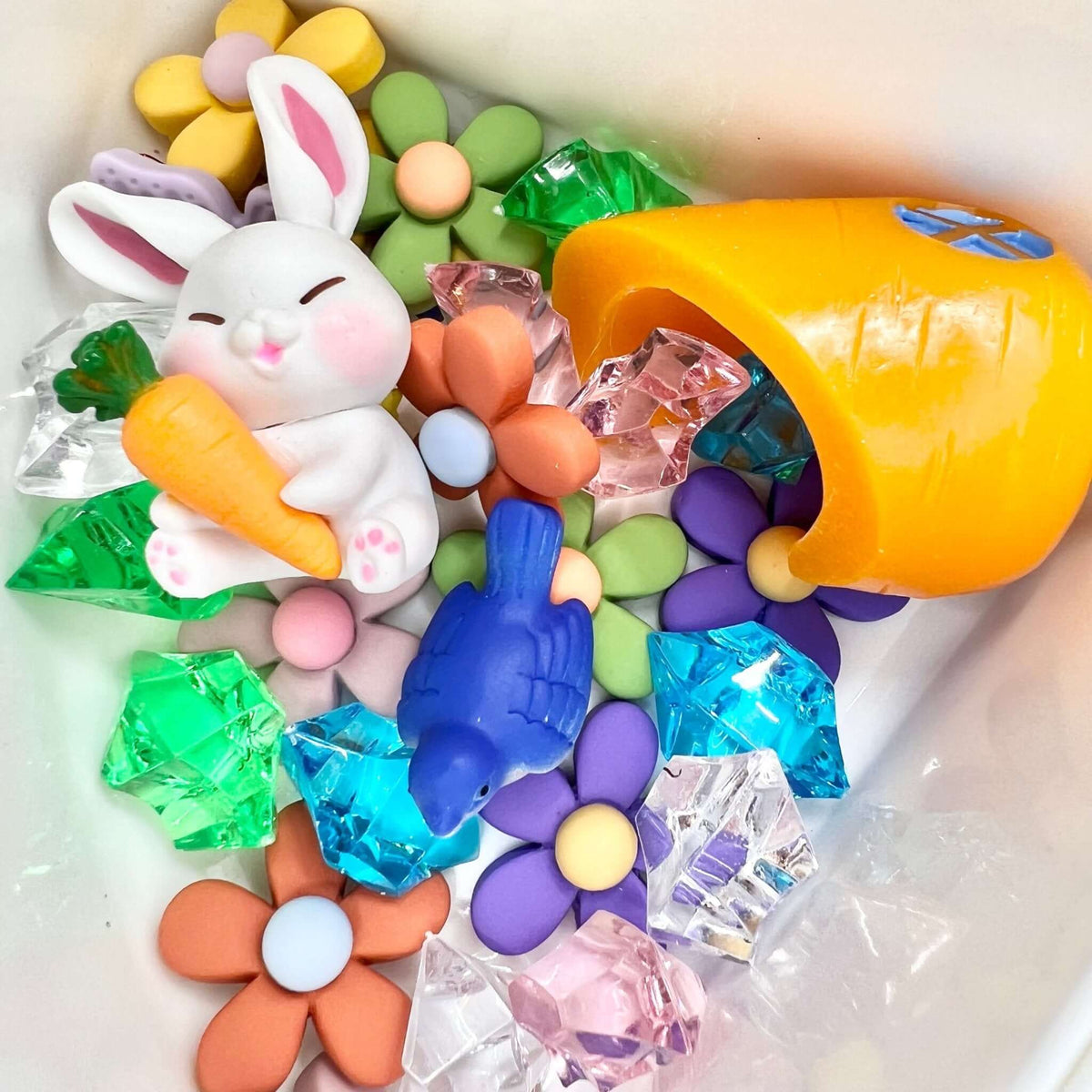 Bunny, flowers and gems in a storage compartment; the pictured carrot house is not included