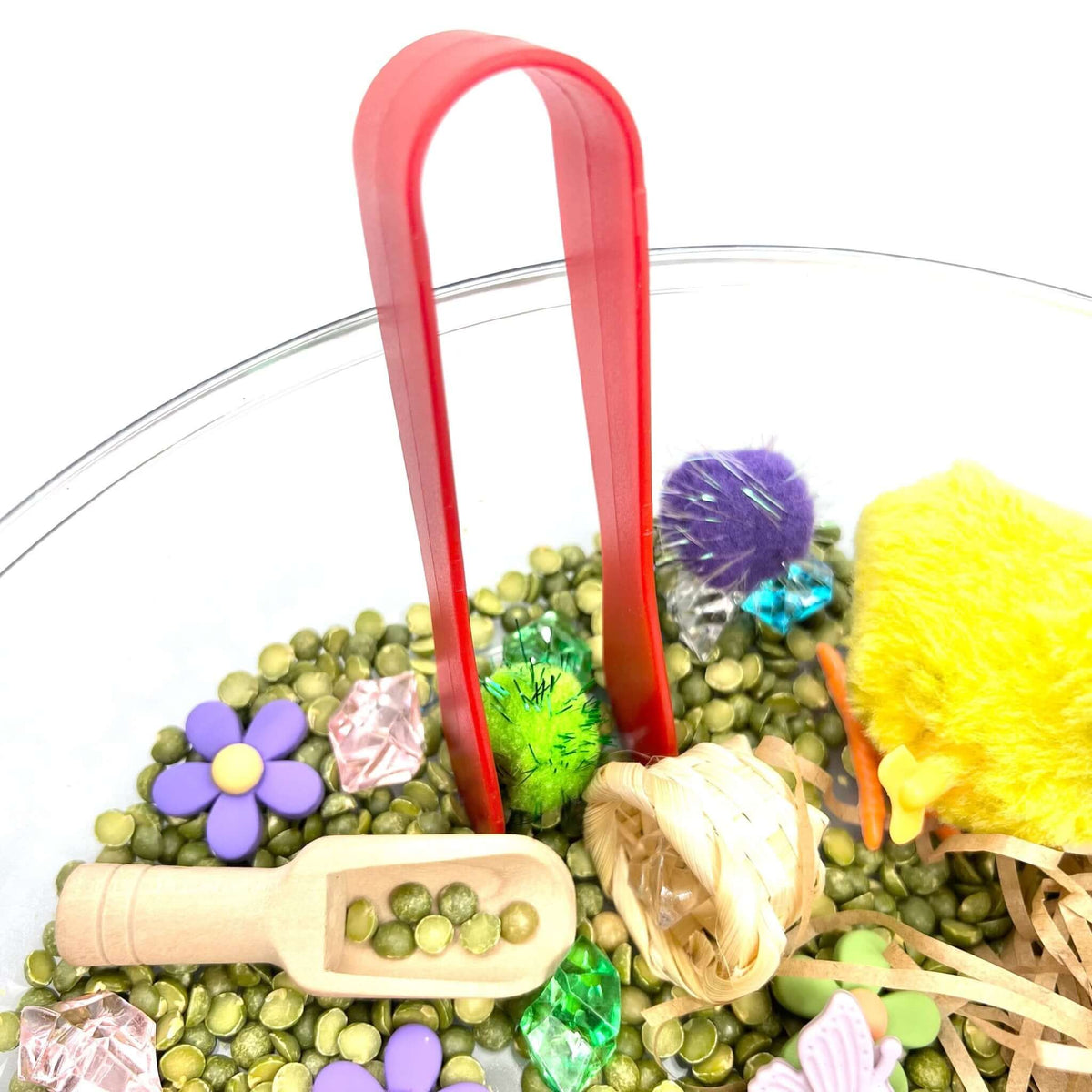 Red tongs, scoop and small basket in the Spring Garden sensory tray
