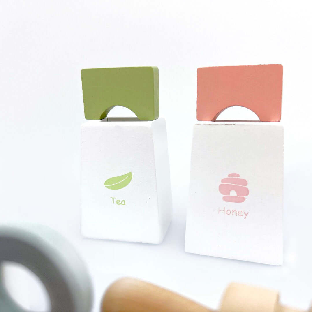 Miniature tea and honey containers in green, pink and white