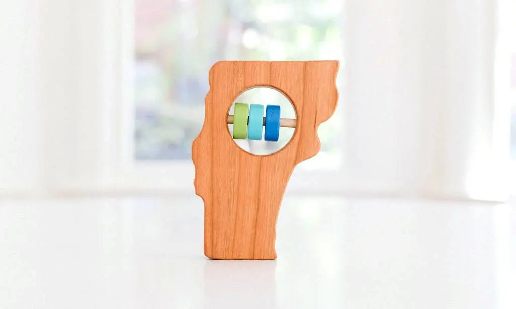 Bannor Toys Vermont State Wooden Baby Rattle, showing state-shaped cherry-wood body and colored rattle discs