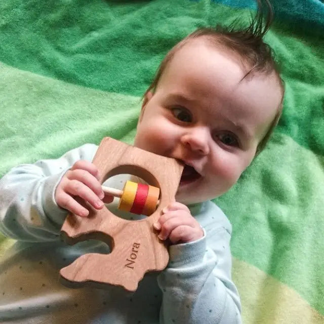 Lifestyle photo showing a wooden state rattle with a child