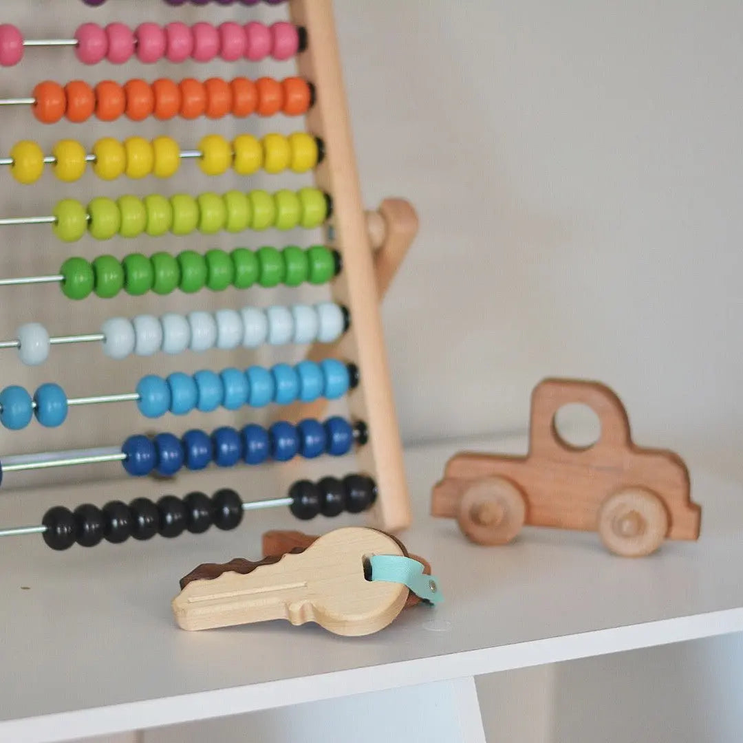 Wooden toy keys displayed with an abacus and a toy truck