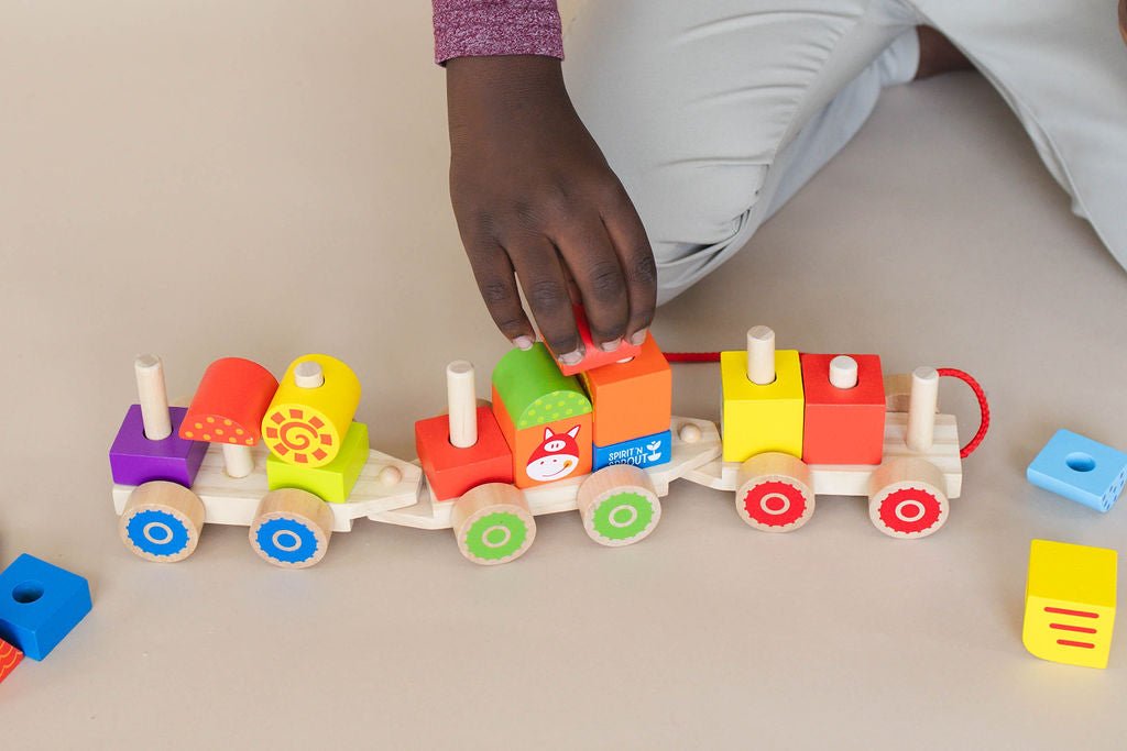 SpiritnSprout: Close-up of hands rearranging blocks on the farm train