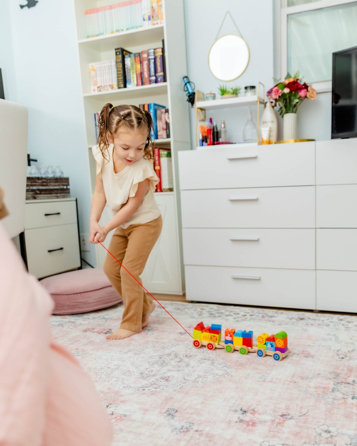 SpiritnSprout: Child pulling the farm stacking train beside a sofa