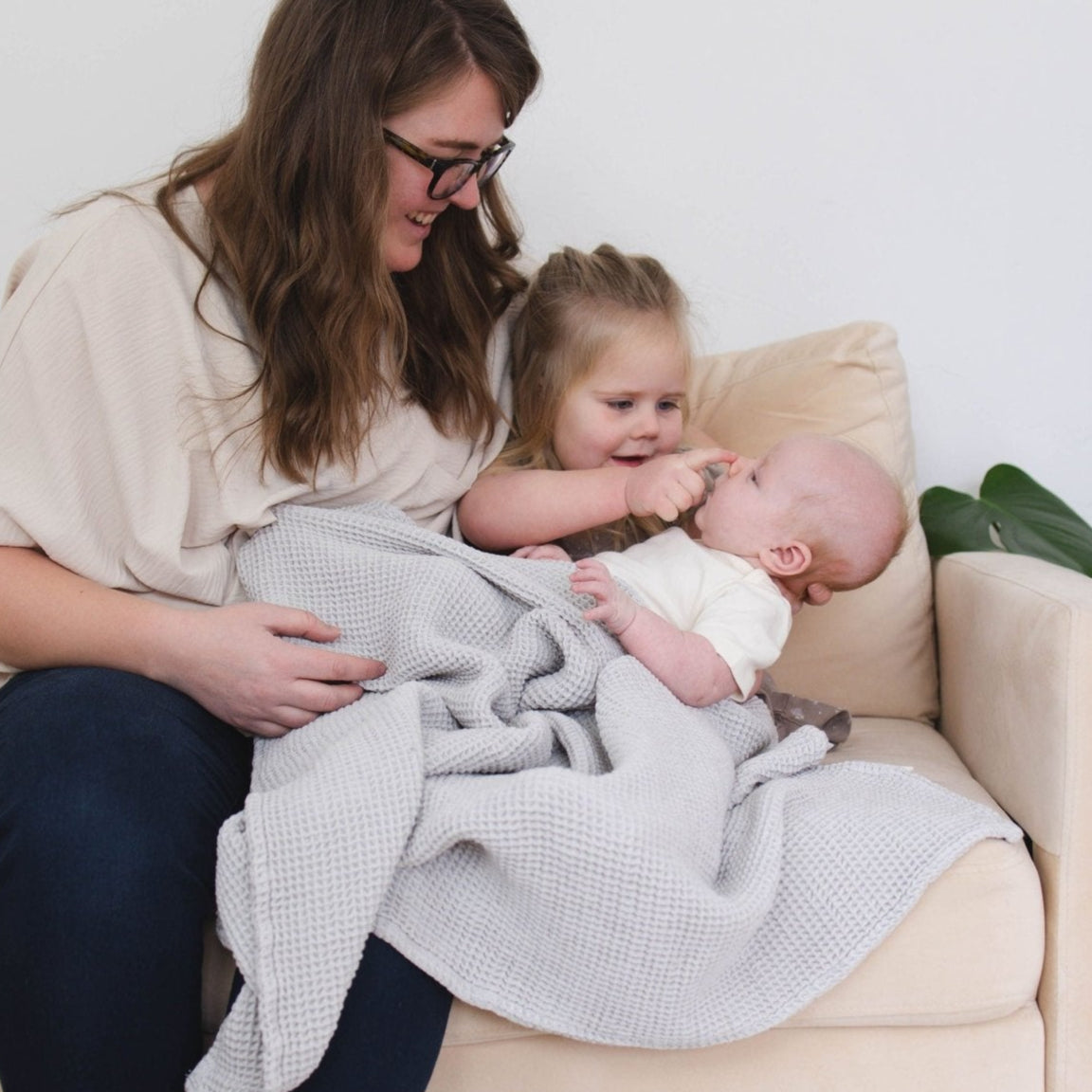 SpiritnSprout: Caregiver seated with children and a grey blanket