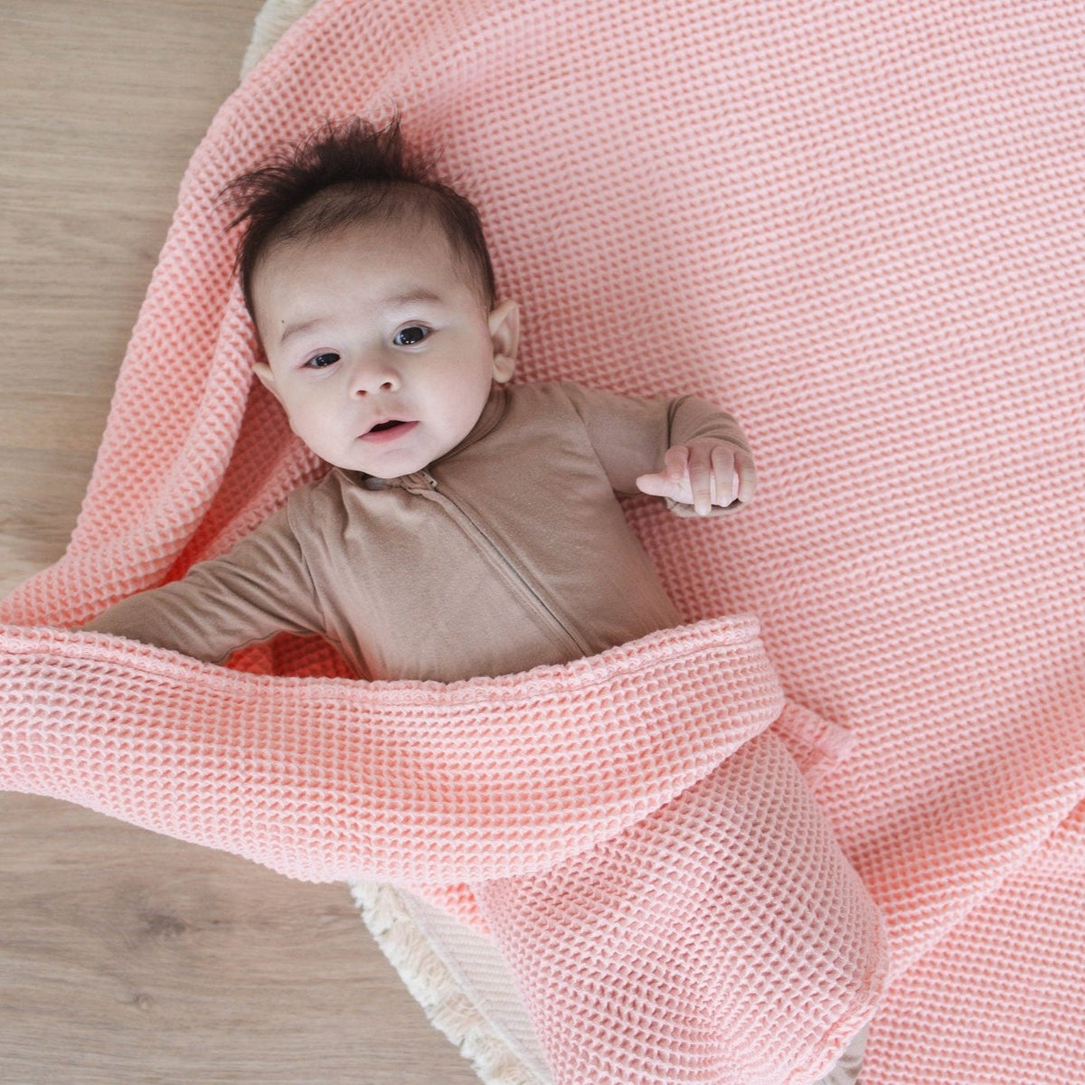 SpiritnSprout: Baby lying awake on a rose pink waffle blanket